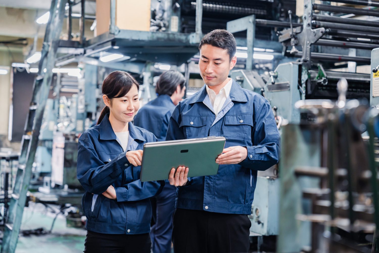 people in a factory looking at a screen