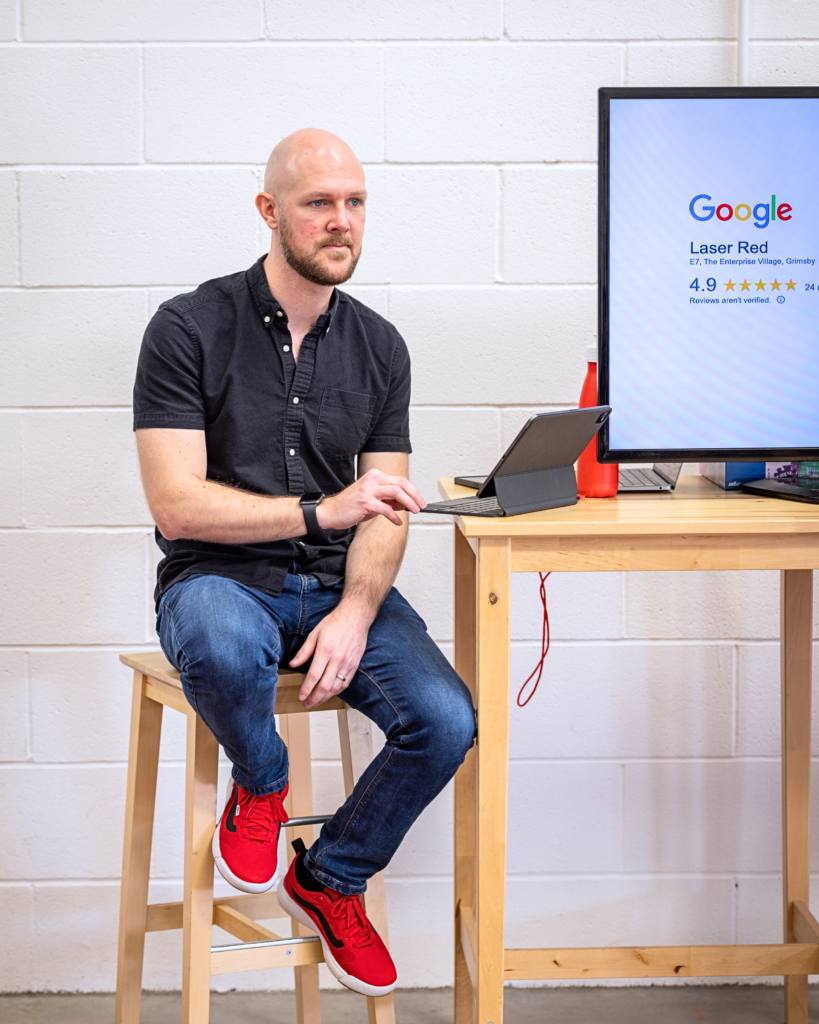 man sat on chair presenting information on a tv screen to an award winning digital agency