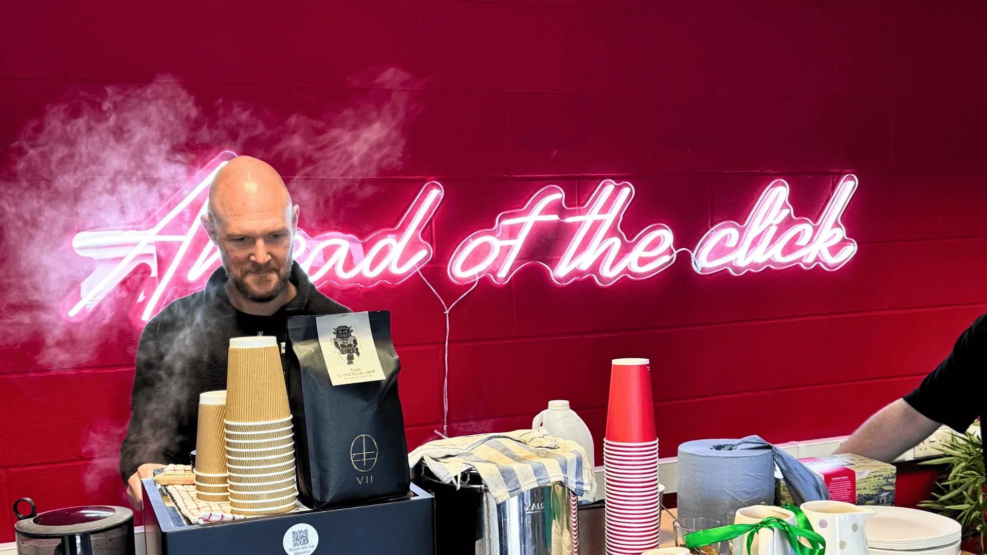 liam enojying using his coffee machine infront of a neon